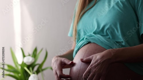 Pregnant woman gently scratching her big naked belly. Skin stretching during pregnancy. 4K