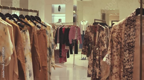 Cinematic close-up of elegant women’s clothing hanging on a rack and softly moving in warm light. Cozy, stylish boutique atmosphere perfect for fashion, advertising, and social media videos.