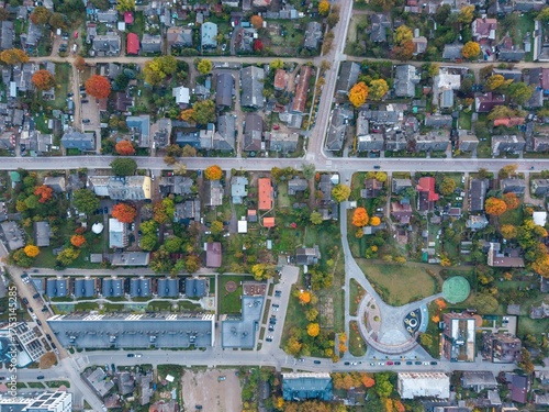 Aerial drone view of Šnipiškės district in Vilnius, Lithuania during autumn. Old wooden houses contrast with new streets and modern city development.