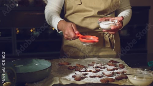 Woman Dusting Homemade Gingerbread Cookies with Powdered Sugar for Christmas