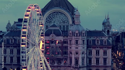 Evening over Antwerp city, bustling streets with cars and pedestrians, cinematic aerial view capturing urban energy and city lights.