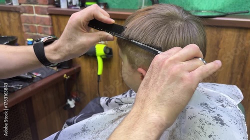 Haircut of a little boy in a children hairdressing salon