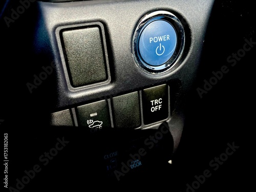 A close-up of a vehicle's lower dashboard panel featuring the blue illuminated 