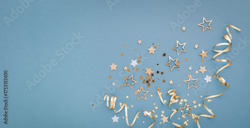 New Year, Christmas or birthday blue festive background top view. Celebration composition with golden confetti stars and serpentine party streamers.