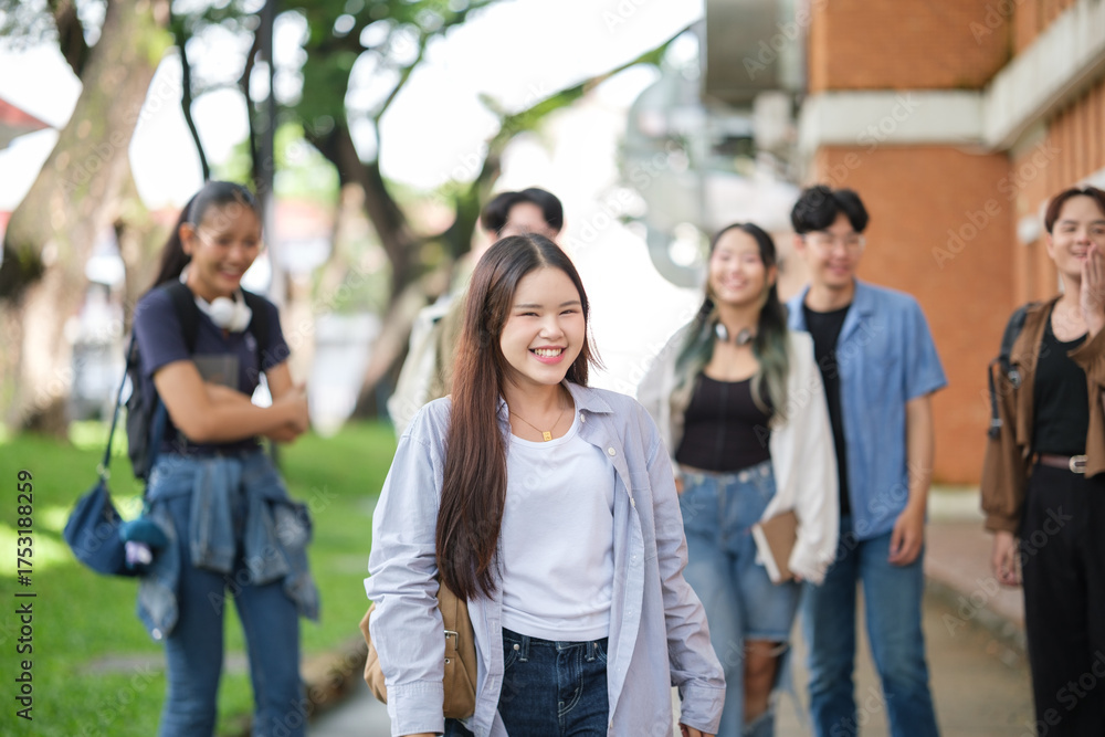Obraz premium Happy university students walking together on campus, enjoying friendship and good vibes.