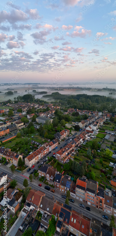 Fototapeta premium Bergensesteenweg, Sint-Pieters-Leeuw, Brussels, Belgium, 13th of May, 2025, A stunning aerial shot captures a peaceful neighborhood beautifully nestled in nature during a breathtaking sunrise
