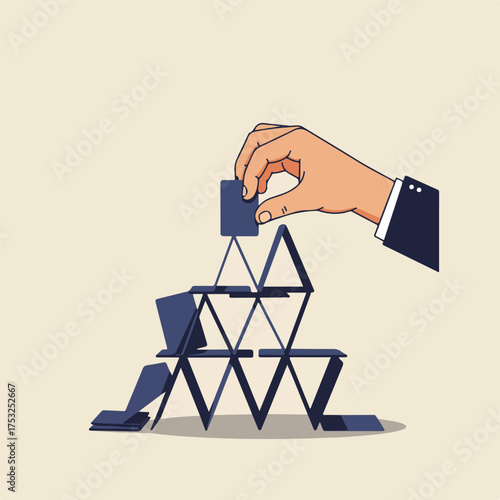 A hand in a suit places the final card atop a precarious house of cards