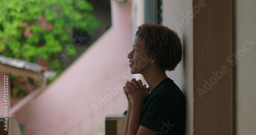 Fotografie One Hispanic young boy of African descent with curly hair, eyes closed, hands cl