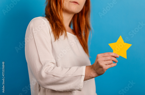Woman holding yellow star c...