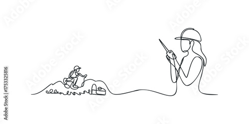 Two people one in a hard hat operating a tool on a mound and another in a hard hat speaking into a device