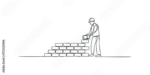 Bricklayer constructing wall with brick and helmet