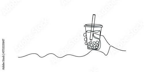 Hand holding a bubble tea drink with straw and pearls