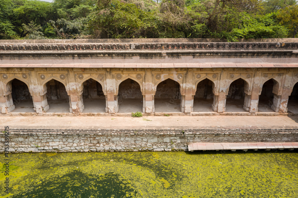 Fototapeta premium This landscape photo was taken in Asia, India, Delhi, Delhi, in summer. It shows the Rajon Ki Baoli stepwell of the Mehrauli archaeological complex in Delhi, under the Sun.