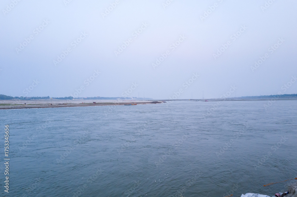 Obraz premium This landscape photo was taken in Asia, India, Uttar Pradesh, Prayagraj, in summer. It shows the Ganges and Yamuna at Sangam in Prayagraj, under the Sun.