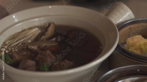 Bak-kut-teh is a pork rib dish.Dim Sum is traditional chinese food, people traditionally enjoy in restaurants for breakfast and lunch. Close up of Steamed Dim Sum in bamboo dish at chinese restaurants