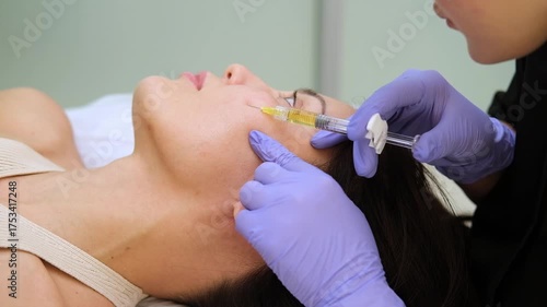Doctor Cosmetologist is Making Rejuvenating Injection Procedure for Smoothing Wrinkles. Beautiful Woman in Beauty Salon. Injection Contour Plastic Surgery.