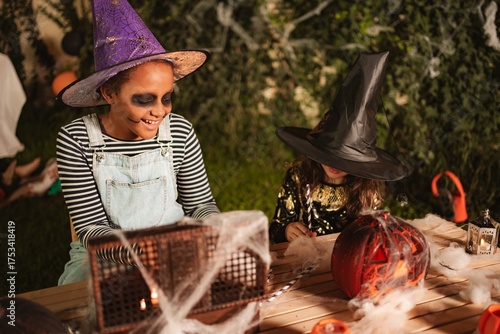 Two girls making Halloween decorations at home