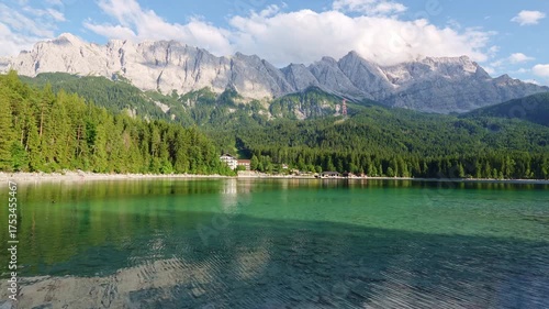 Eibsee Lake, Mountain Slopes with Forest and Zugspitze Massif on Sunny Day. Ripple on Water. Bavaria, Germany