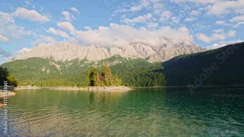 Eibsee Lake, Mountain Slopes with Forest, Island and Zugspitze Massif at Sunset. Ripple on Water. Bavaria, Germany
