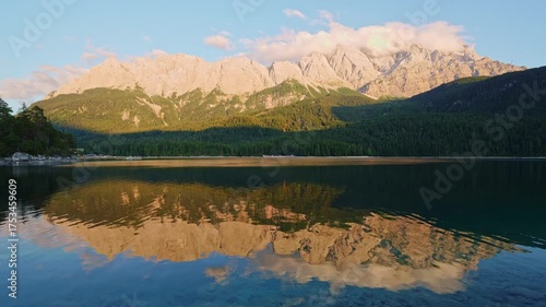 Eibsee Lake, Mountain Slopes with Forest and Zugspitze Massif at Sunset. Reflection on Water. Bavaria, Germany