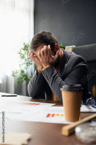 Stressed businessman suffering headache and burnout at office desk