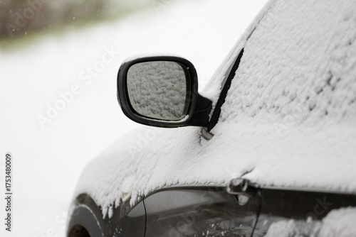 eine Detailaufnahme eines Autos, Autotür, Außenspiegel im Winter, eingeschneit es liegt Schnee