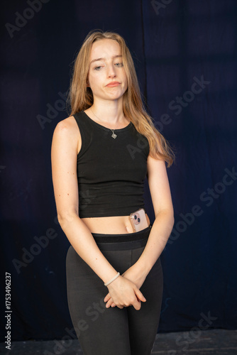 A pensive young woman in a black outfit displays subtle emotions, creating a thoughtful mood. The image captures her inner world and quiet contemplation beautifully.