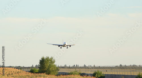 Passenger plane over the forest in the blue sky, the sun is shining. Transport, travel. High quality photo