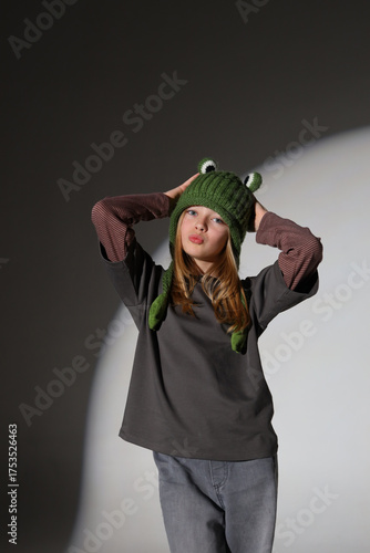 Caucasian female teen in frog hat and casual outfit posing confidently
