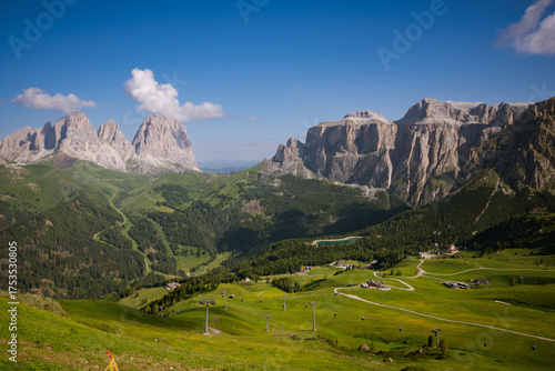 Mountain landscape in the Dolomites on a sunny summer day with green meadows, mountains and blue sky