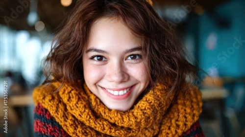 Wallpaper Mural A close-up portrait of a smiling young woman, showcasing her joyful expression while wrapped in a cozy, knitted scarf, highlighting warmth and charm in a vibrant setting. Torontodigital.ca