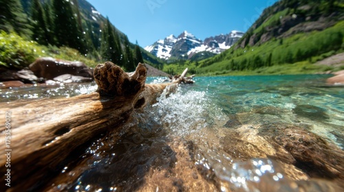 A serene view of a forest lake surrounded by towering snow-capped mountains, showcasing the beauty of nature reflected in the clear blue water.