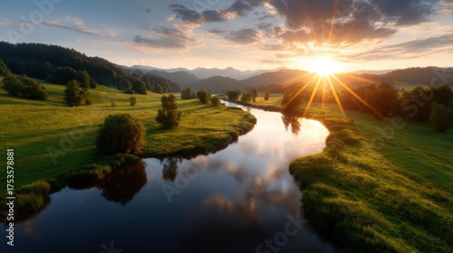 A breathtaking sunset illuminates the hills and river, creating a stunning reflection and enhancing the natural beauty of this serene landscape with vibrant colors.