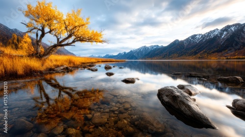 A stunning landscape featuring a golden tree beside a tranquil lake, surrounded by majestic mountains and reflective waters, capturing the beauty of nature at its finest.