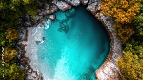 An aerial view of a crystal clear tropical lagoon, surrounded by vibrant green foliage and golden rocks, showcasing nature's beauty in a serene and tranquil atmosphere.