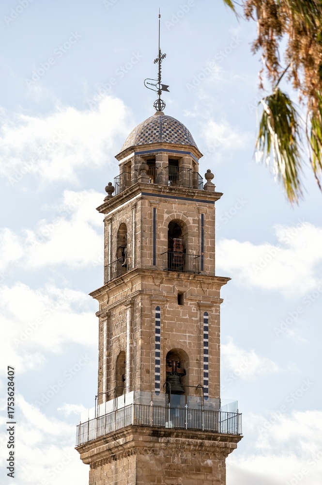 Naklejka premium The elegant bell tower of San Miguel Church in Jerez de la Frontera, Andalusia, Spain, standing under a bright blue sky