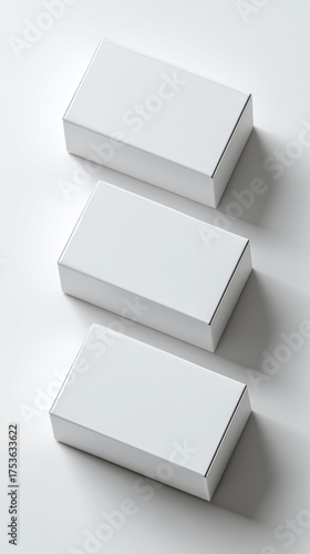 Three blank white boxes arranged in a stack on a light surface. The boxes are rectangular and have a clean, minimalistic design.