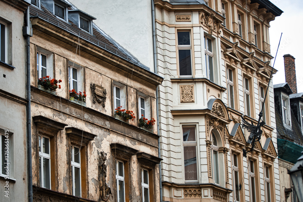 Obraz premium Ornate neoclassical architecture adorns the facade of a historic building, with vibrant floral displays adding a touch of vibrancy to the weathered stone walls.