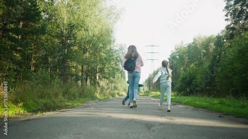 Wallpaper Mural Rear view of joyful family running playfully down tarred road through serene forest area, with kids and older sister enjoying outdoor moment, surrounded by tall trees and soft morning sunlight Torontodigital.ca
