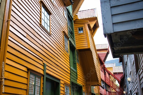 Canvas Print Colorful, weathered wooden buildings line a quaint alley in a historic Norwegian town, creating a charming and picturesque scene