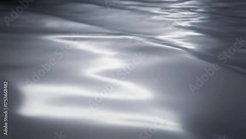 Smooth metallic surface reflecting light waves, elegant shimmering motion background with minimal futuristic tone