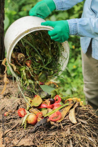Compost heap pile with bio waste. Farmer, gardener with vegetables and fruits food scraps from bucket in compost. Zero waste, composting concept
