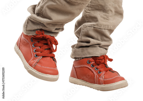Child's feet in red shoes and tan pants, walking