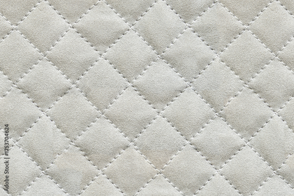 Naklejka premium Quilted fabric texture background with a classic geometric diamond pattern and soft padding. Ideal for textiles upholstery and creative design projects.