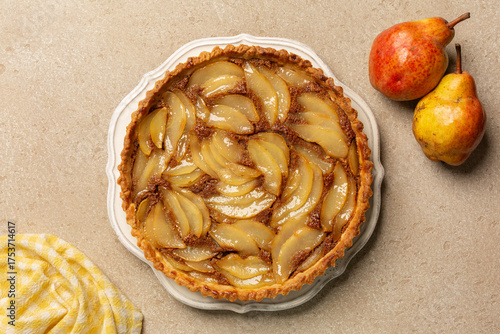 Top view of classic French poached pear tart, made with a sweet frangipane, almond  cream.