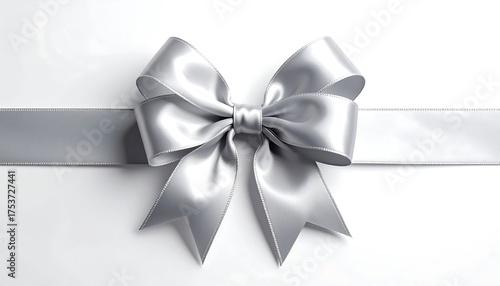 A shiny, metallic silver bow crafted from a ribbon sits centered against a crisp, white, reflective background, creating a simple, elegant aesthetic
