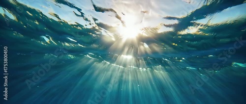 A serene and magical underwater shot of sunlight rays breaking through the water's surface. Creates a peaceful, hopeful, and ethereal mood. Clean and beautiful abstract background.