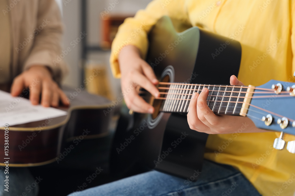 Fototapeta premium Private music teacher giving guitar lessons to boy in room, closeup
