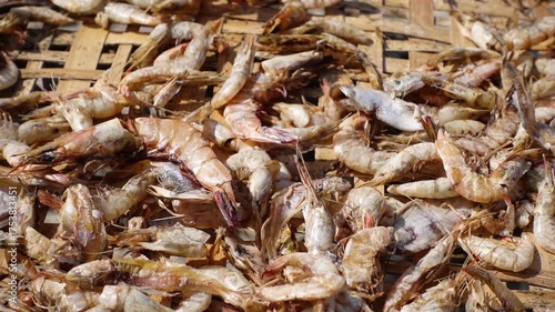 A close-up view of half-dried shrimp on a bamboo basket.