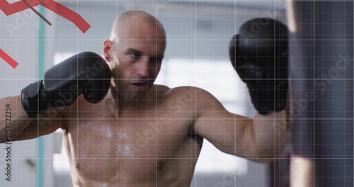Photos Punching shirtless bald man delivering punch on heavy punching bag in gym, with